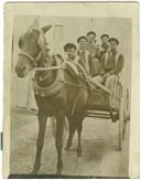 Grupo de homens em carroça puxada por cavalo.
