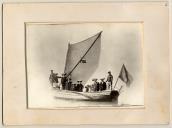 Reprodução fotográfica de barco à vela com tripulação e passageiros.